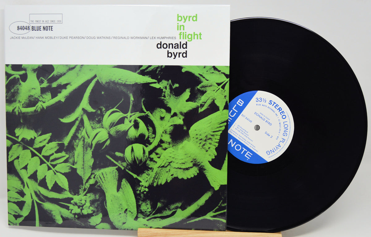 Donald Byrd's 'Byrd in Flight' vinyl record album, showing the front cover with a green and black bird illustration and the black LP record partially pulled out, revealing the blue and white record label.