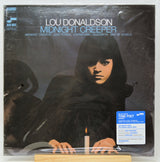 Lou Donaldson 'Midnight Creeper' vinyl record LP cover, sealed in plastic with a blue Tone Poet sticker on the bottom right, displayed on a wooden stand.