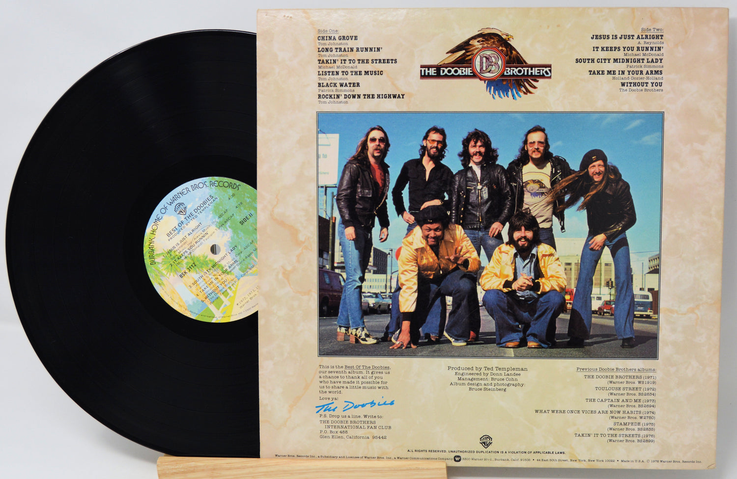 Vinyl record with cover featuring a group photo and text
