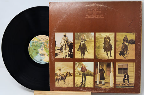 Vinyl record with a brown cover featuring images of people on horses and a dog.