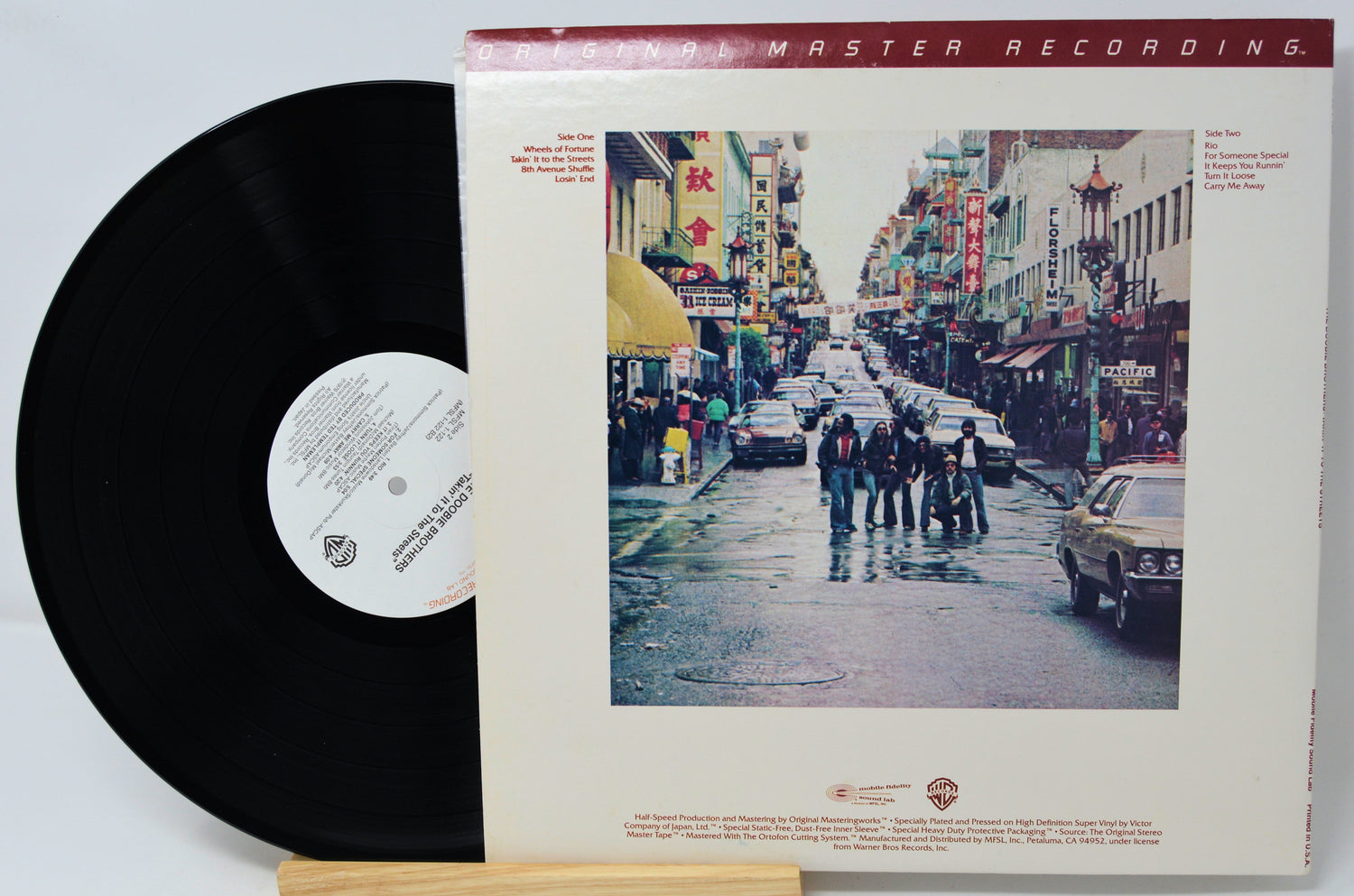Vinyl record with cover featuring a street scene and 'Master Recording' text.