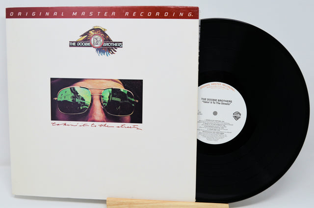 Vinyl record and cover with 'The Doobie Brothers' album on a white background