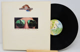 Vinyl record with cover featuring a person wearing sunglasses and a logo at the top.