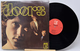 Vinyl record and cover with 'The Doors' album art on a white background