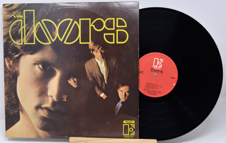 Vinyl record and cover with 'The Doors' album art on a white background