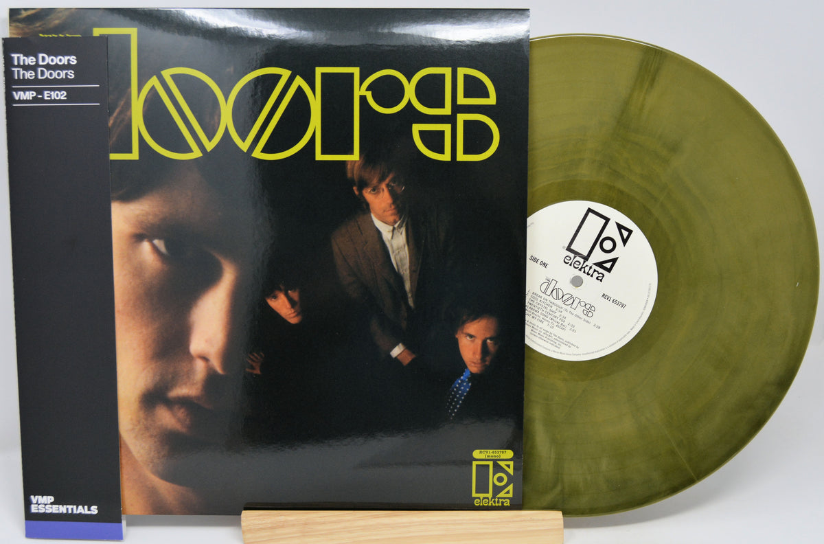 The Doors 'Light' vinyl record LP with its album cover sleeve and a translucent olive-green vinyl disc displayed on a small wooden stand.
