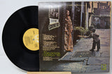 Vinyl record with cover featuring a woman and child on a stone path.