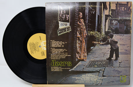 Vinyl record with cover featuring a woman and child on a stone path.