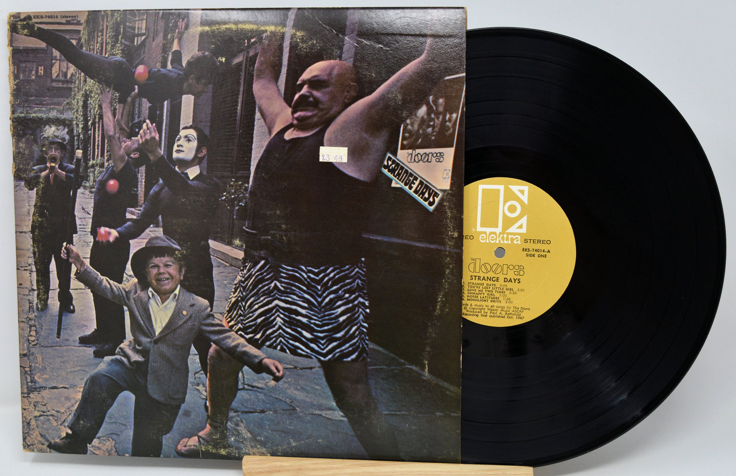 Vinyl record with a colorful cover featuring people on a street scene.
