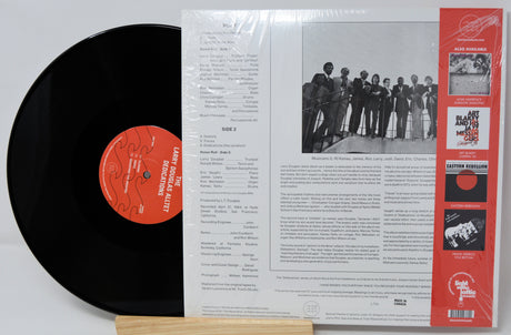 Vinyl record with a black label and red label, and its packaging on a white background