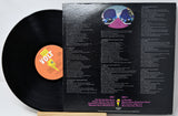 A vinyl record partially pulled from its black outer sleeve, showing the back of the packaging with printed track listings and a circular album art illustration. The record label reads VOLT.