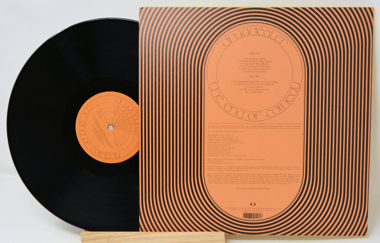 Vinyl record with orange label and black cover on a white background