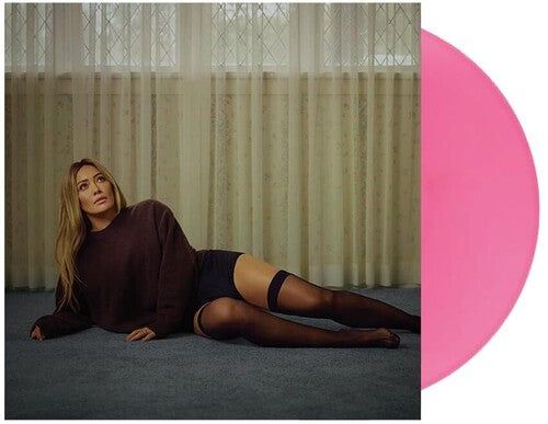 Woman lying on the floor wearing a dark sweater and black stockings with a pink circle overlay.