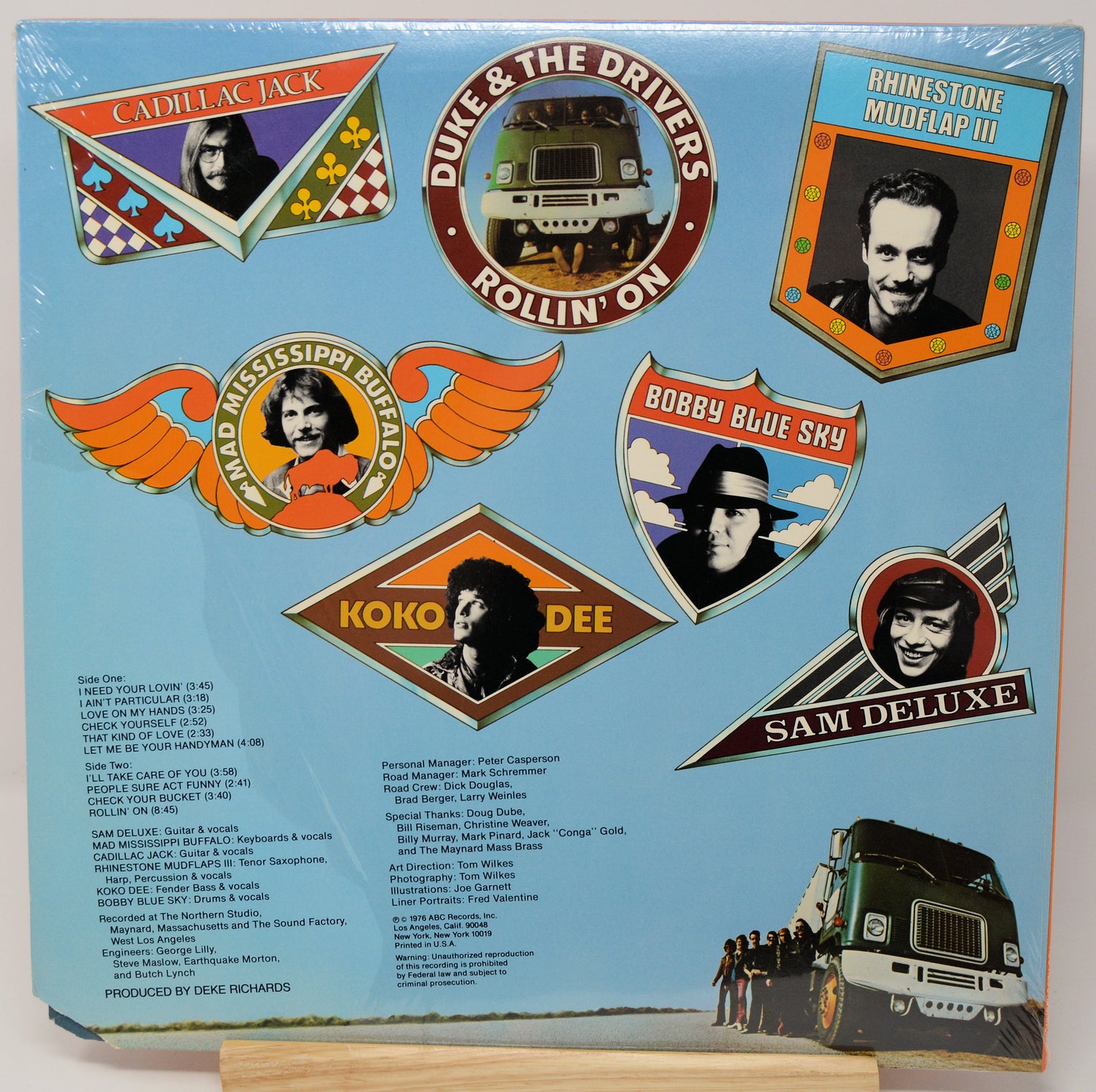 Album cover with various music labels and a truck illustration on a blue background