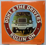 Vinyl record cover for 'Duke & The Drivers Rollin' On' with a green truck on an orange background
