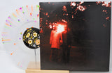 Vinyl record with a cover featuring two people under a tree, surrounded by flowers.