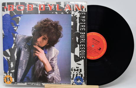 Vinyl record with 'Bob Dylan Empire Burlesque' cover showing a person with curly hair.