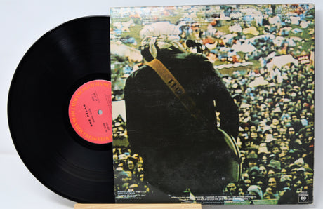 Vinyl record with a colorful album cover featuring a person in a crowd.