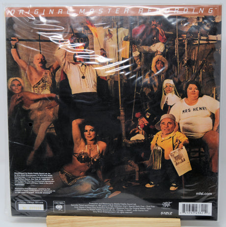 The back cover of the 'Original Master Recording' vinyl LP for Marilyn Manson's album 'The Game', sealed in its plastic shrink-wrap and displayed on a wooden stand.