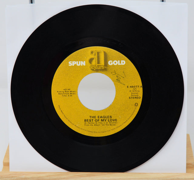 Vinyl record with yellow label featuring 'Spun Gold' and 'The Eagles' on a white background