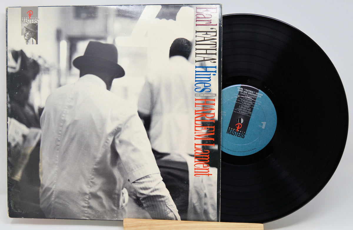 A vinyl record partially pulled from its sleeve, showing the black disc and the album cover with a black-and-white photo and vertical red text reading 'FREDERICK BINGHAMS HARRY Mudditt.'.
