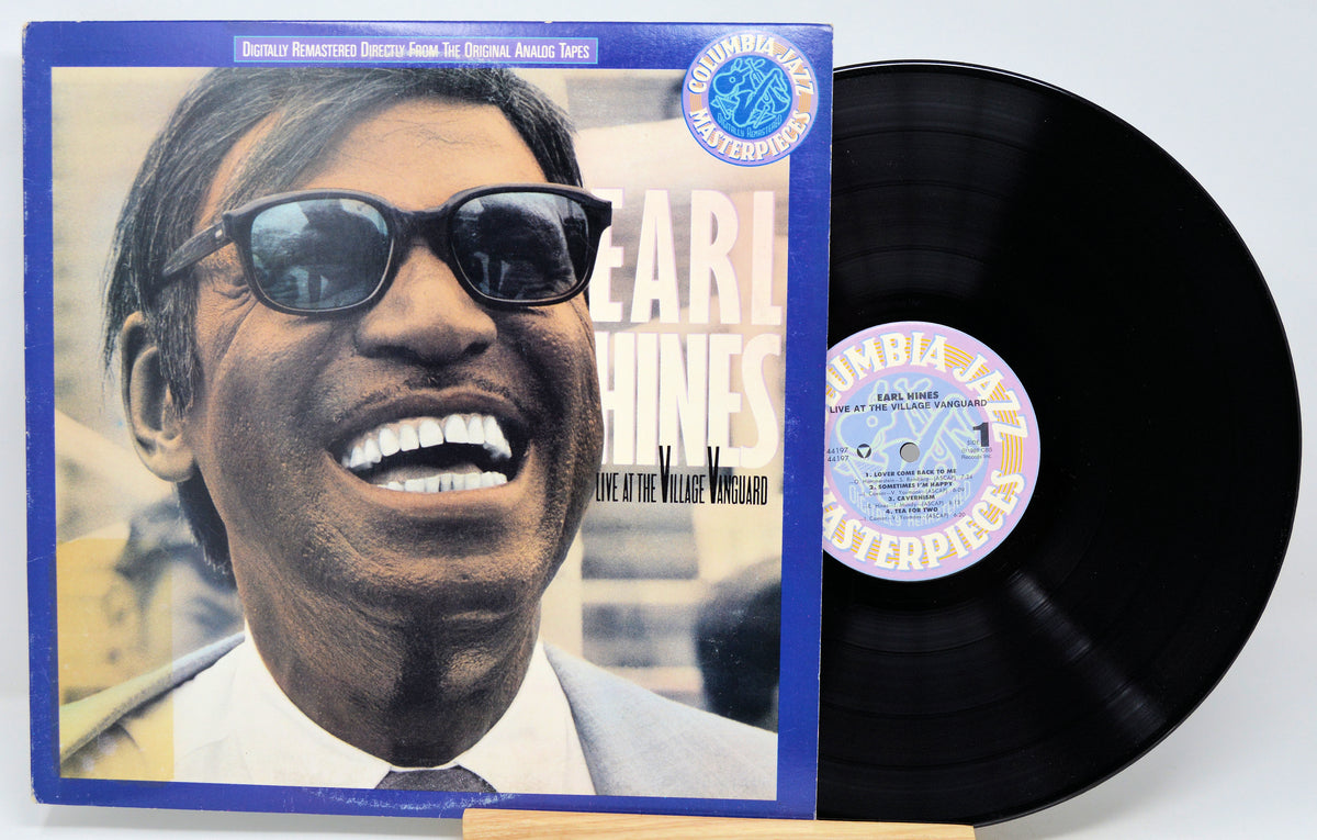 A vinyl record album with its cover partially pulled from the record, photographed on a white background. The cover features a smiling man wearing sunglasses and the text 'Earl Williams' and 'Live at the Village Vanguard.