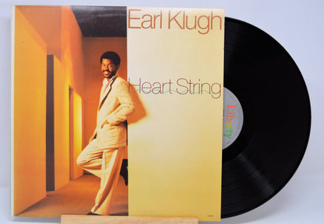 Vinyl record with 'Earl Klugh Heart String' album cover showing a person in a suit.
