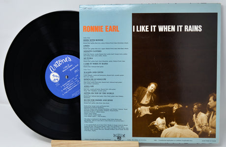 Vinyl record with cover featuring a band and text on a light gray background