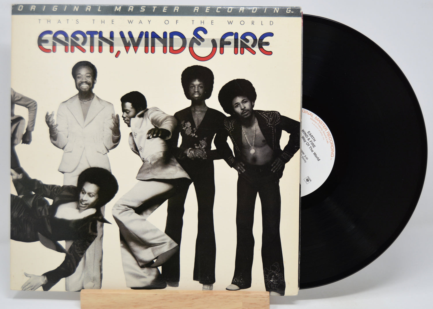 Vinyl record with 'Earth, Wind & Fire' titled 'That's The Way Of The World' album cover showing band members.