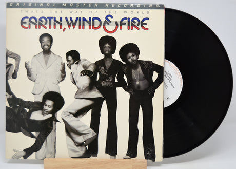 Vinyl record with 'Earth, Wind & Fire' titled 'That's The Way Of The World' album cover showing band members.
