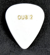 White guitar pick with 'OU812' engraving on a dark textured background