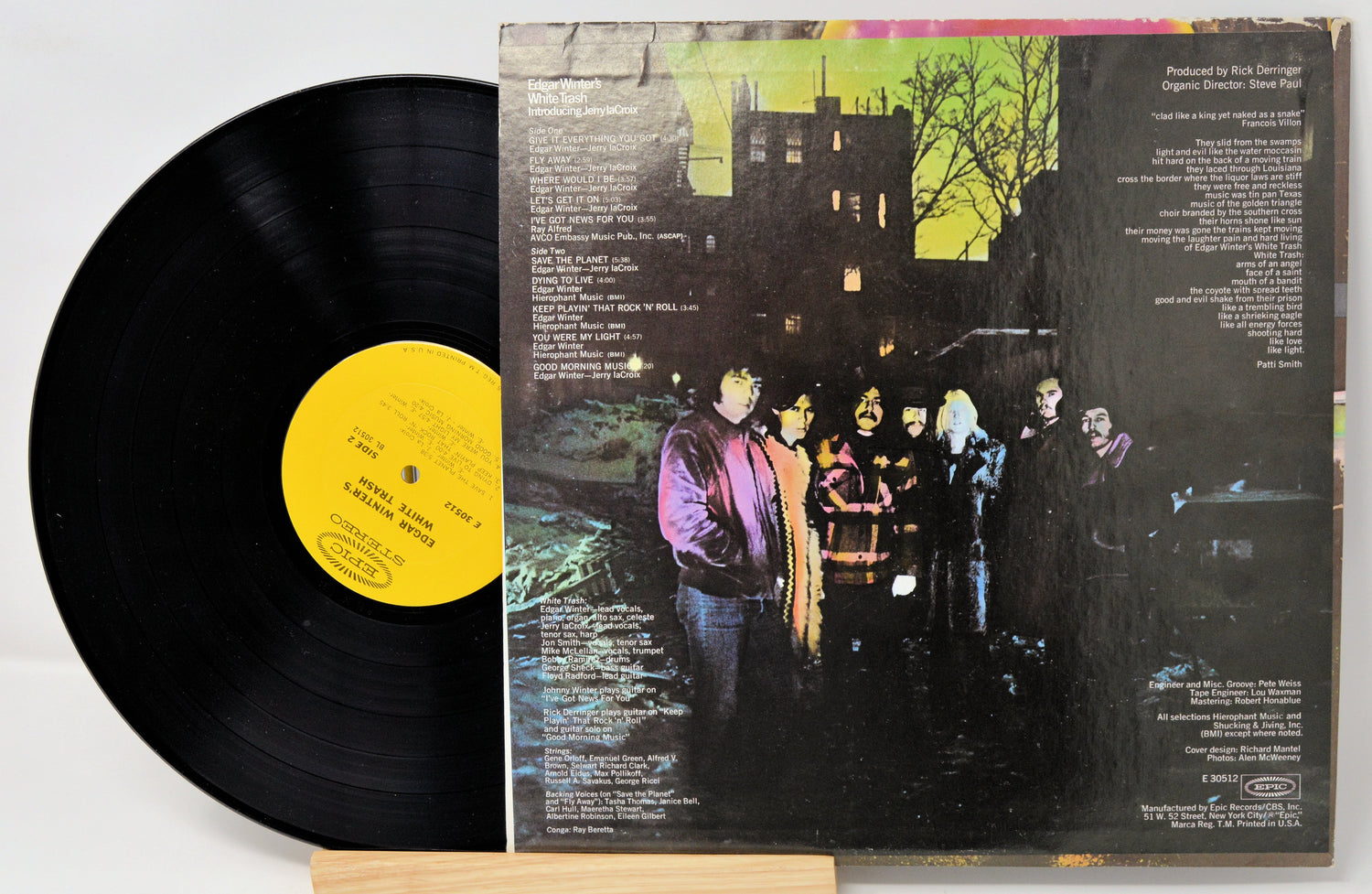 Vinyl record with a colorful cover featuring people around a car.