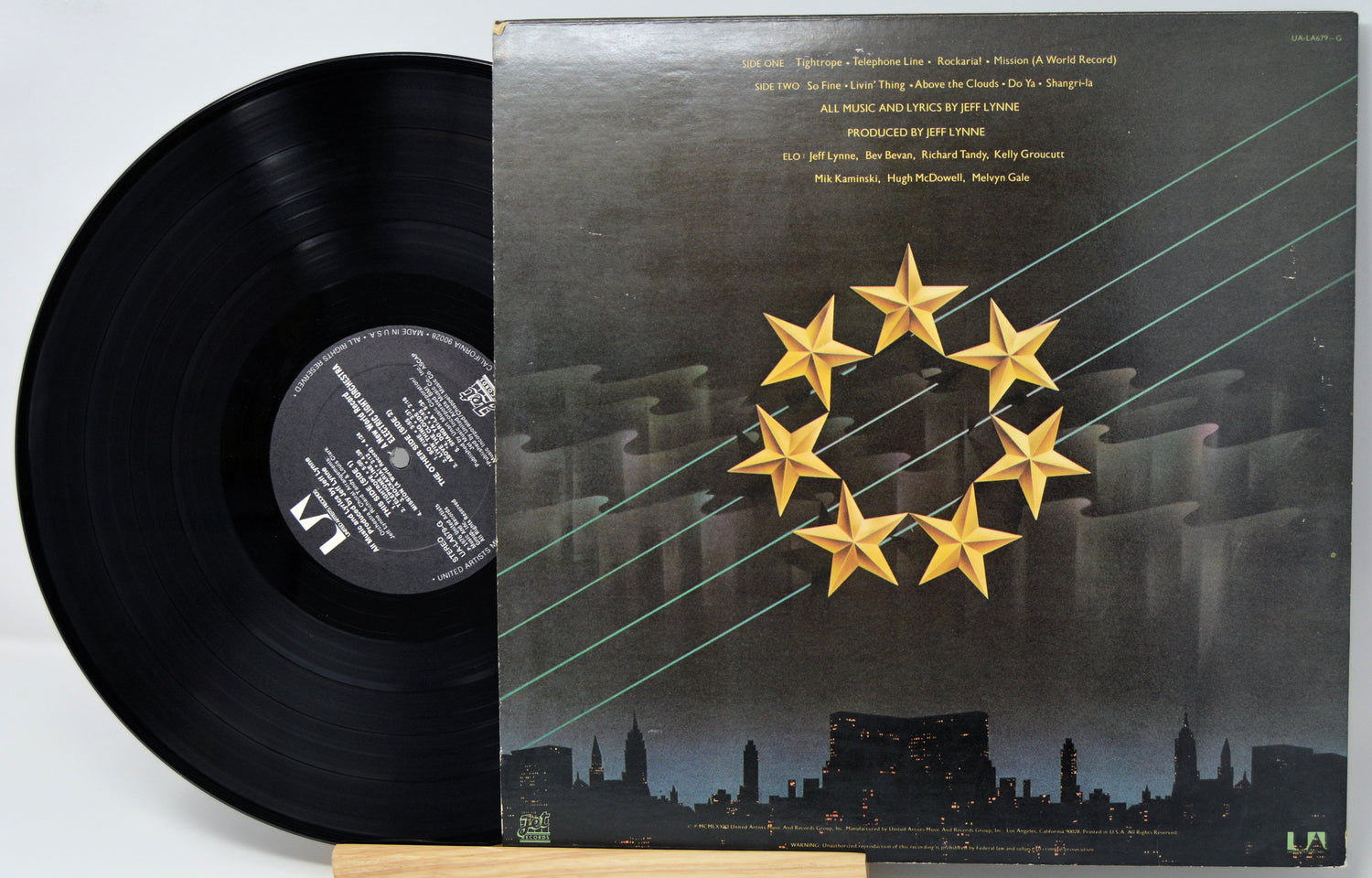 Vinyl record with a cover featuring a star design on a cityscape background