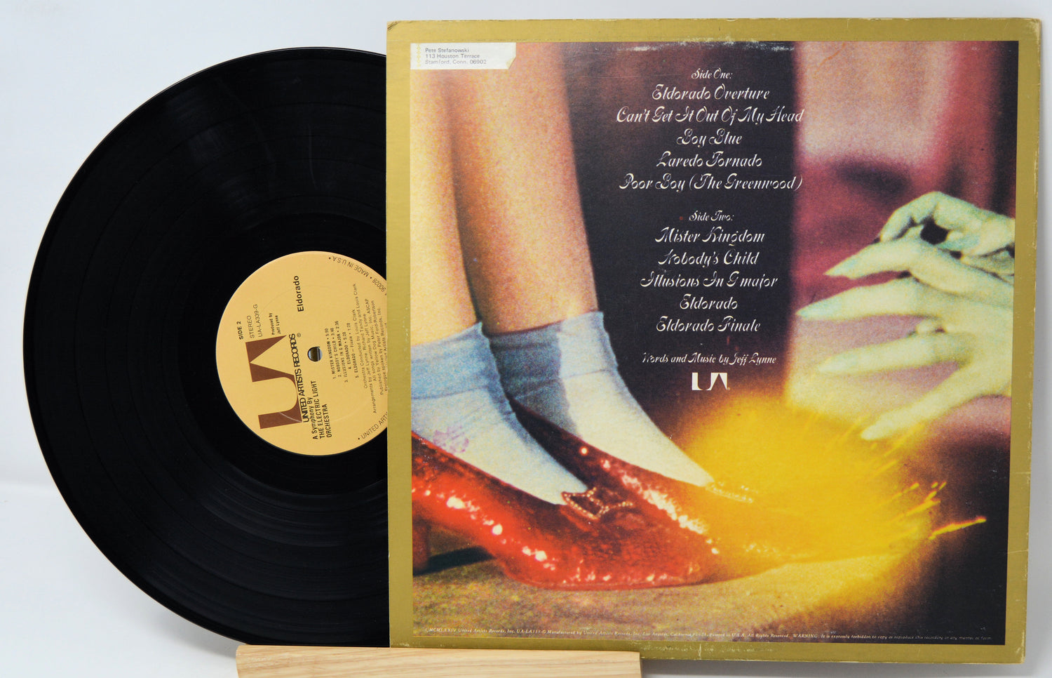 Vinyl record with a colorful cover featuring a person's feet in red shoes and white socks.