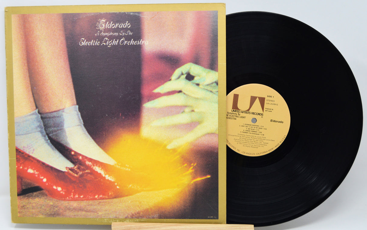 Vinyl record with cover featuring a person in red shoes and gray socks, on a white background.