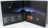 Vinyl record cover with a group of people standing on a mountainous landscape.