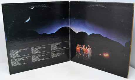 Vinyl record cover with a group of people standing on a mountainous landscape.