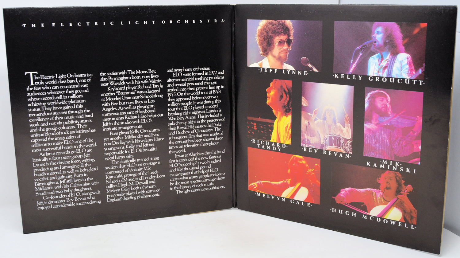 An open printed booklet or program spread for 'The Electric Light Orchestra', showing black pages with white text on the left and a collage of six colorful concert photos on the right. Visible names in the photo grid include Jeff Lynne, Kelly Groucutt, Richard Ford, Bev Revan, Kaminski, Kelvin Cale, and Hugh McDowell.