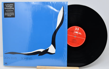 Vinyl record with blue cover featuring a minimalist design and red label.