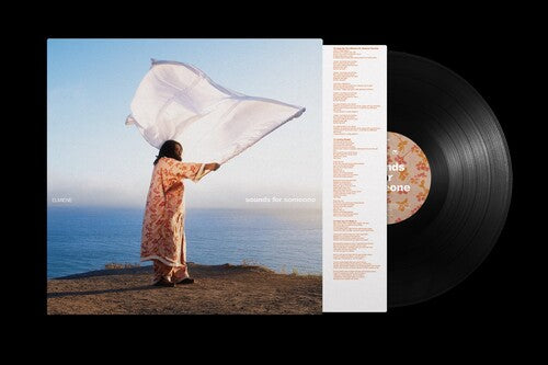 Vinyl record with a person holding a white flag by the ocean on the cover