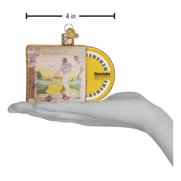 Hand holding a 4-inch Elton John 'Goodbye Yellow Brick Road' album ornament with record detail