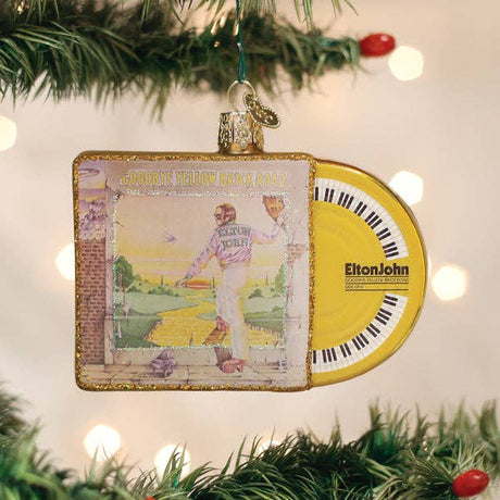 Elton John 'Goodbye Yellow Brick Road' ornament hanging on lit Christmas tree