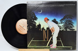 Vinyl record with its cover featuring a person playing golf at night.