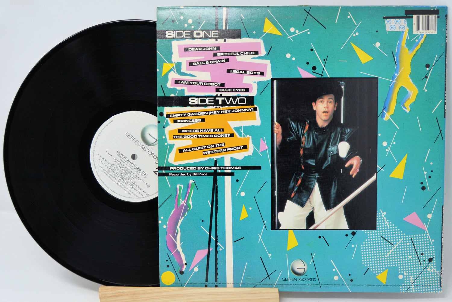 Vinyl record with a colorful cover featuring a person and abstract designs.