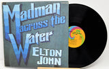 Vinyl record and cover of 'Madman Across the Water' by Elton John on a white background