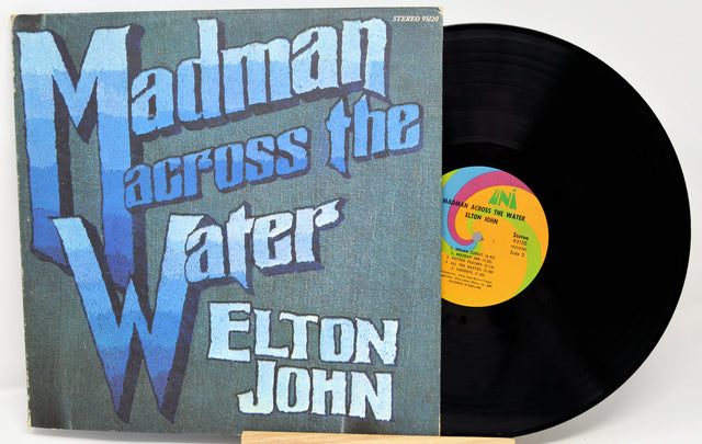 Vinyl record and cover of 'Madman Across the Water' by Elton John on a white background