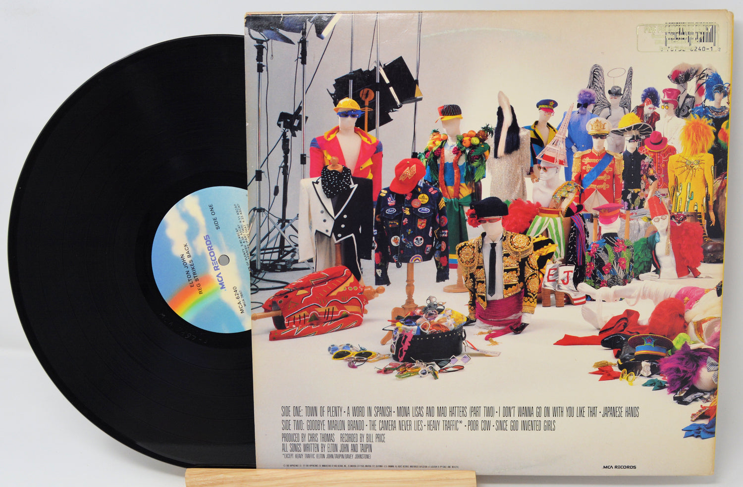 Vinyl record with a colorful album cover featuring people and objects.