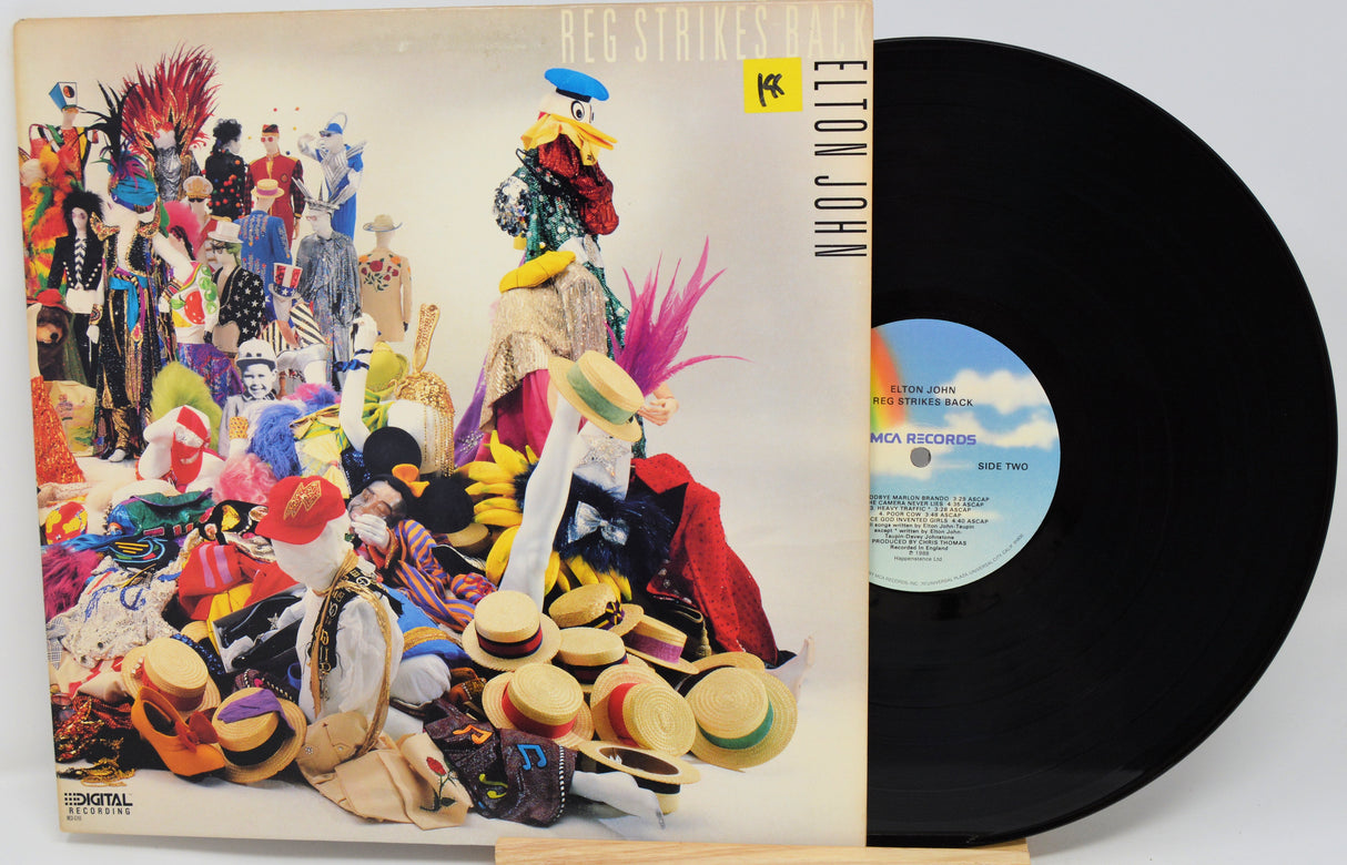 Vinyl record with colorful cover featuring people and hats, and a black record.