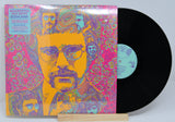 Vinyl record with a colorful cover featuring a portrait of a young Elton John with glasses on a light gray background