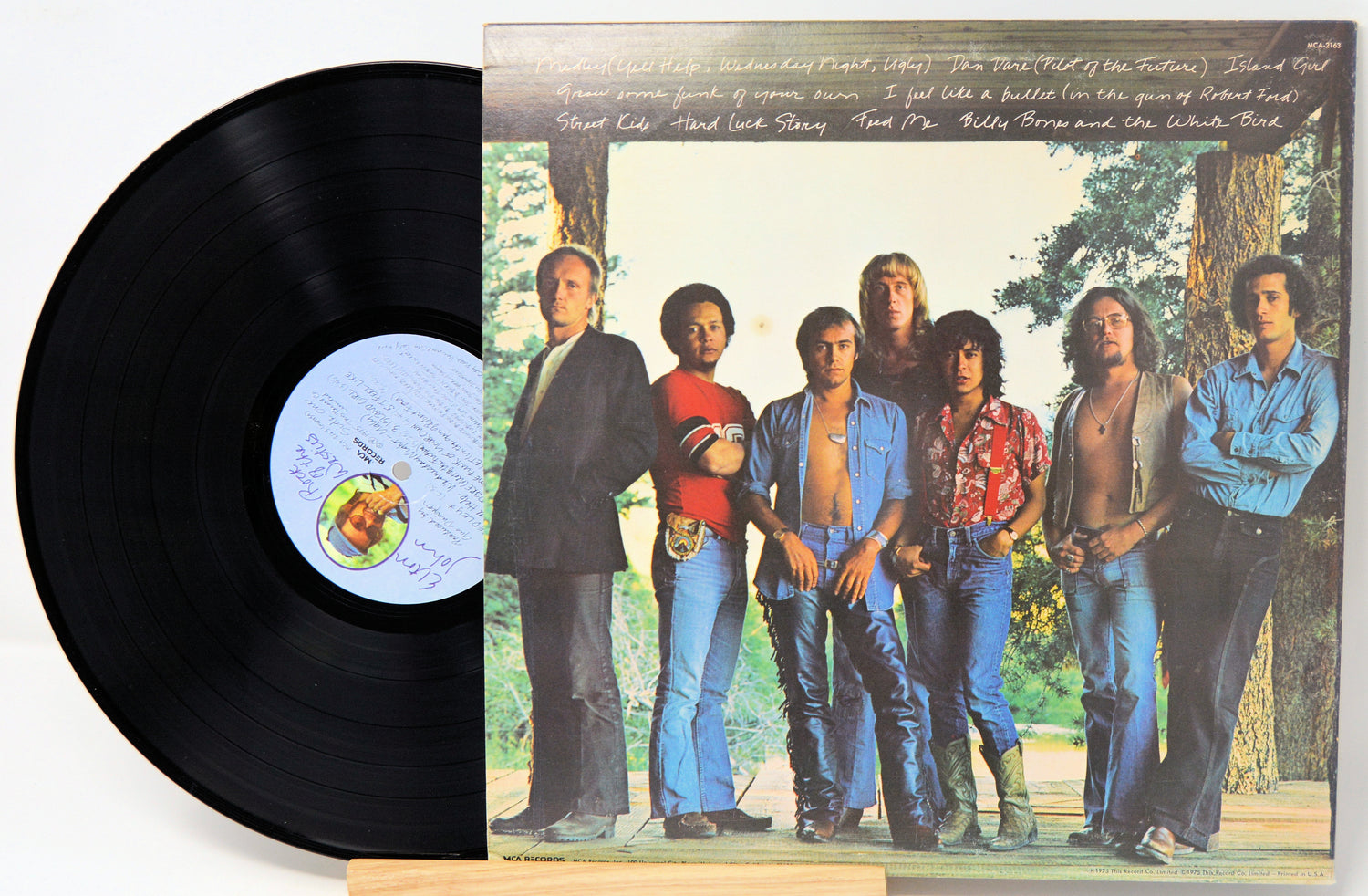 Vinyl record with a colorful cover featuring six people standing outdoors.